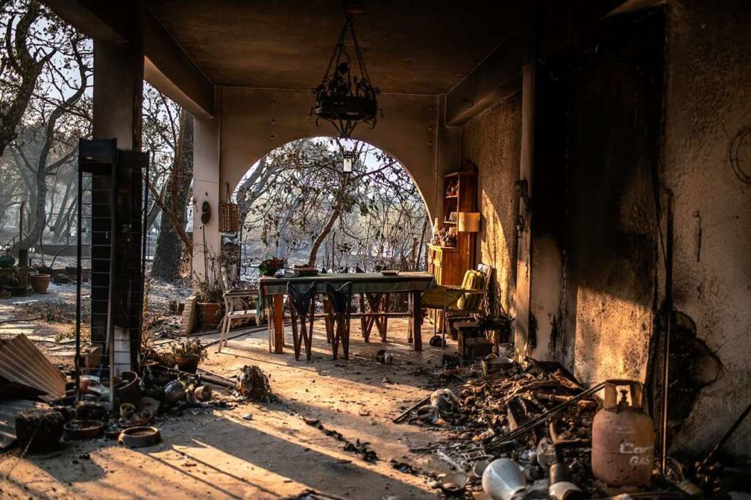 Anwohner bekmpfen das Feuer.  | Foto: Angelos Tzortzinis (dpa)