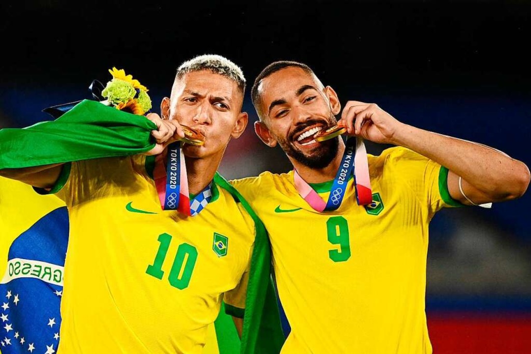 Die Brasilianer Richarlison (links) und Matheus Cunha mit ihren Medaillen.  | Foto: ANNE-CHRISTINE POUJOULAT (AFP)