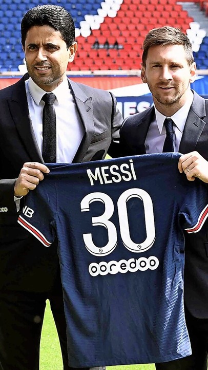 Lionel Messi und PSG-Boss  Nasser Al-K...ieren im Anzug das Trikot des Kickers.  | Foto: STEPHANE DE SAKUTIN (AFP)