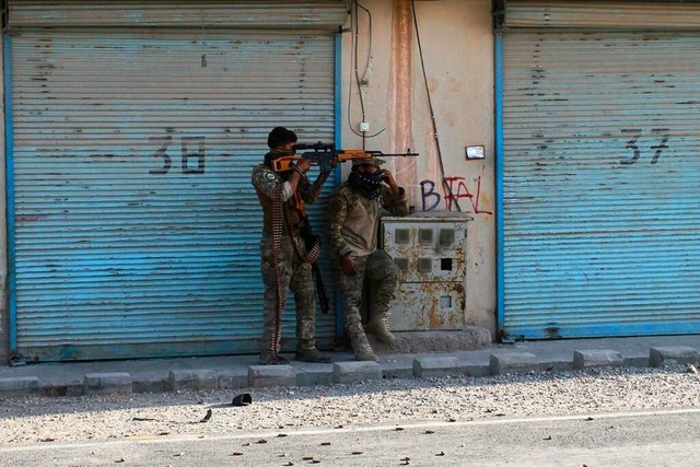 Zwei bewaffnete afghanische Sicherheit...hlsen liegen und kmpfen mit Taliban.  | Foto: Hamed Sarfarazi (dpa)
