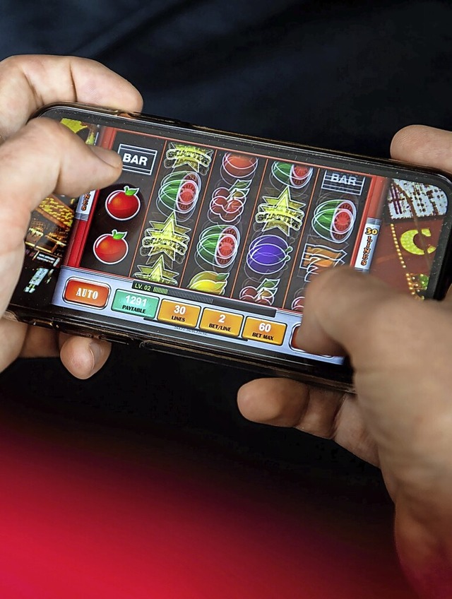 Auf einem Smartphone spielt ein Mann ein Online-Spiel.  | Foto: Sina Schuldt (dpa)