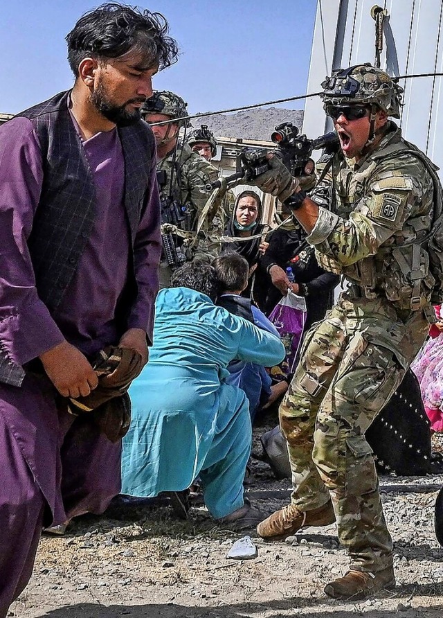 Ein US-Soldat versucht mit gezogener W...schen von den Flugzeugen fernzuhalten.  | Foto: WAKIL KOHSAR (AFP)