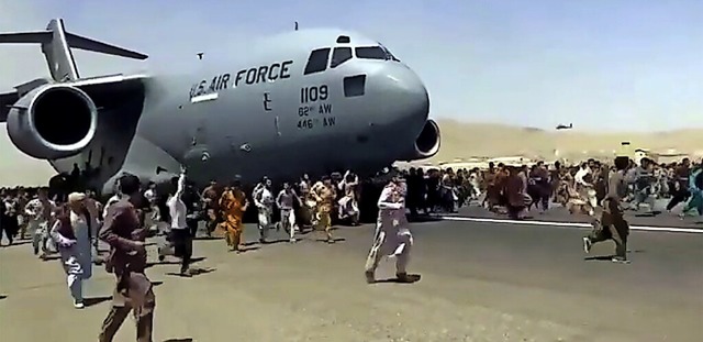 Hunderte Menschen laufen neben einer U...er Flugzeuge zu kommen, um zu fliehen.  | Foto: Uncredited (dpa)