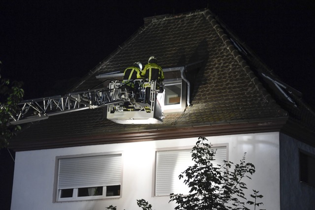 Mit der Drehleiter gelangten Feuerwehrleute von auen zur Dachgeschosswohnung.  | Foto: Volker Mnch