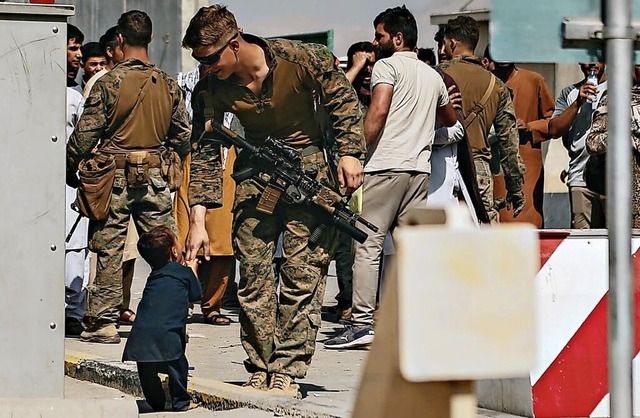 Ein US-Soldat spielt mit einem kleinen Jungen am Flughafen Kabul.  | Foto: Sgt. Isaiah Campbell, U.S. Marine (dpa)