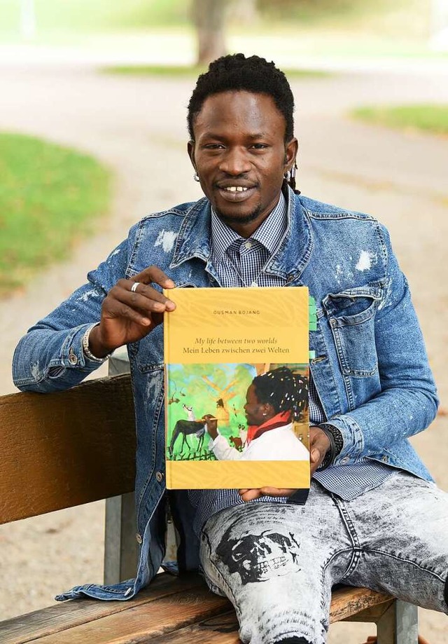 Ousman Bojang prsentiert das Buch mit seinen Bildern.   | Foto: Rita Eggstein