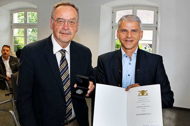 Staatssekretr Patrick Rapp (rechts) ...d die Urkunde des Ministerprsidenten.  | Foto: Daniel Hengst
