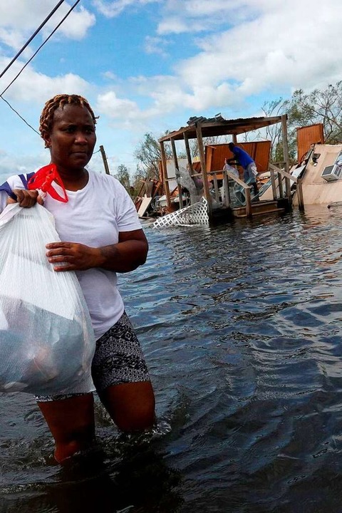 Dina Lewis rettet Gegenstände aus ihrem Haus (rechts) in Laplace, Louisiana.  | Foto: SCOTT OLSON (AFP)