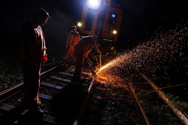 Ein Mitarbeiter der Bahn trennt mit ei...haftes Stck aus einer Schiene heraus.  | Foto: Philipp von Ditfurth (dpa)
