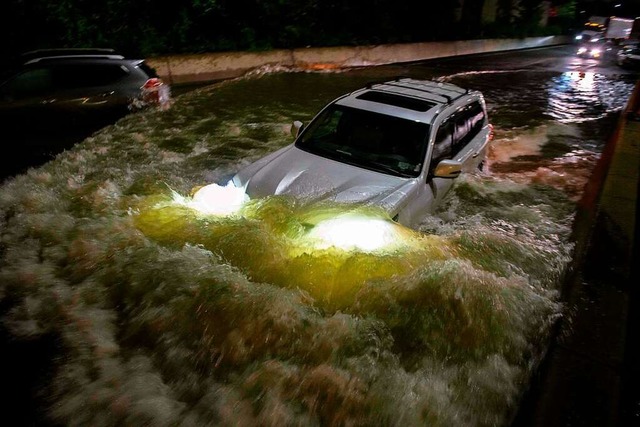 Ein Auto auf einer berfluteten Schnellstrae in New Yorks Stadtbezirk Brooklyn  | Foto: ED JONES (AFP)
