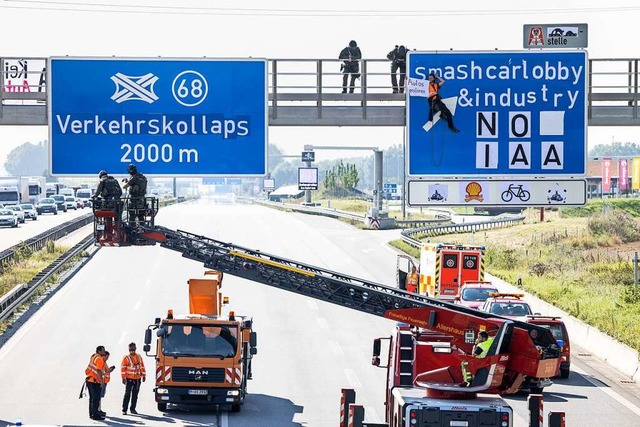 Umweltaktivisten seilten sich von Autobahnschildern ab.  | Foto: Matthias Balk (dpa)