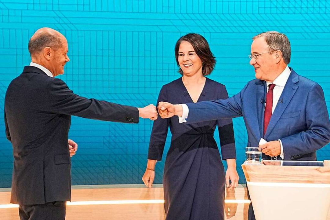 Scholz, Baerbock und Laschet begrüßen sich vor der TV-Debatte.  | Foto: Michael Kappeler (dpa)