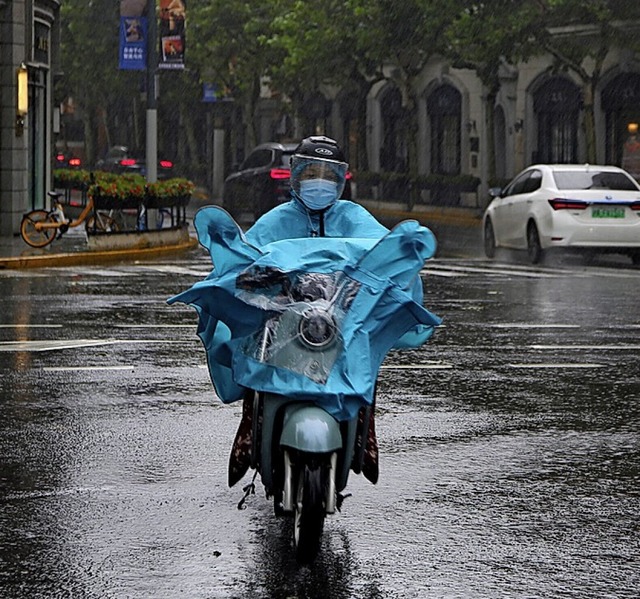 Ein Anwohner fhrt durch Pftzen.  | Foto: Chen Si (dpa)