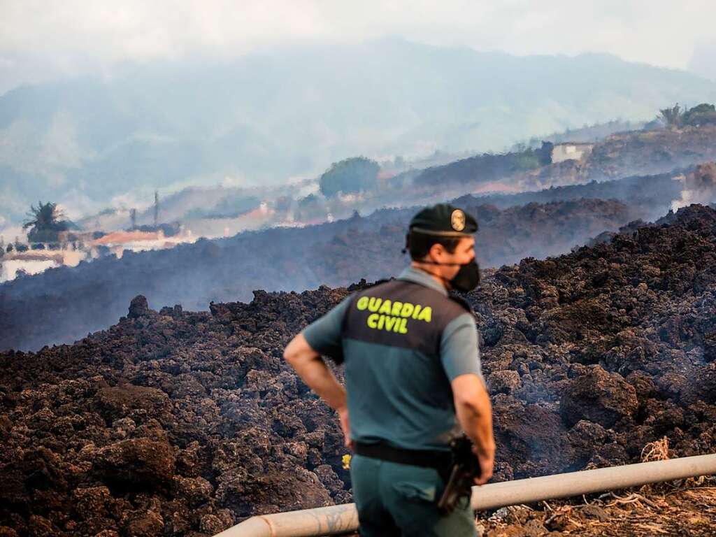 Ein Beamte der Guardia Civil steht vor abgekhlter Lava.