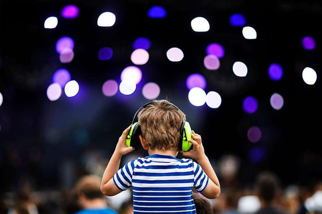 Ein Kind trägt bei einem Konzert Lärms...kopfhörer, um seine Ohren zu schützen.  | Foto: Valentin Flauraud