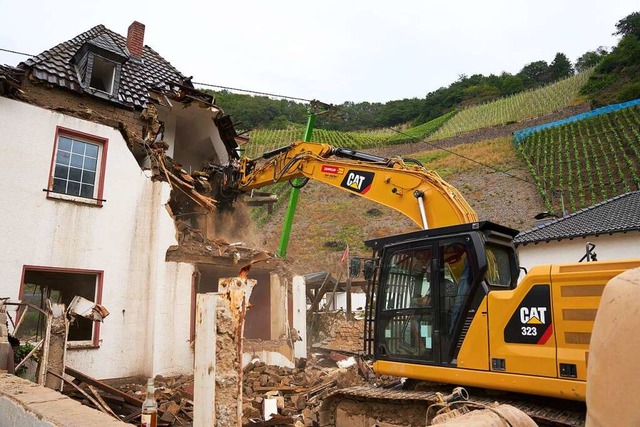 Ein Bagger reit in Dernau ein Haus ab...Flutkatastrophe einsturzgefhrdet ist.  | Foto: Thomas Frey (dpa)