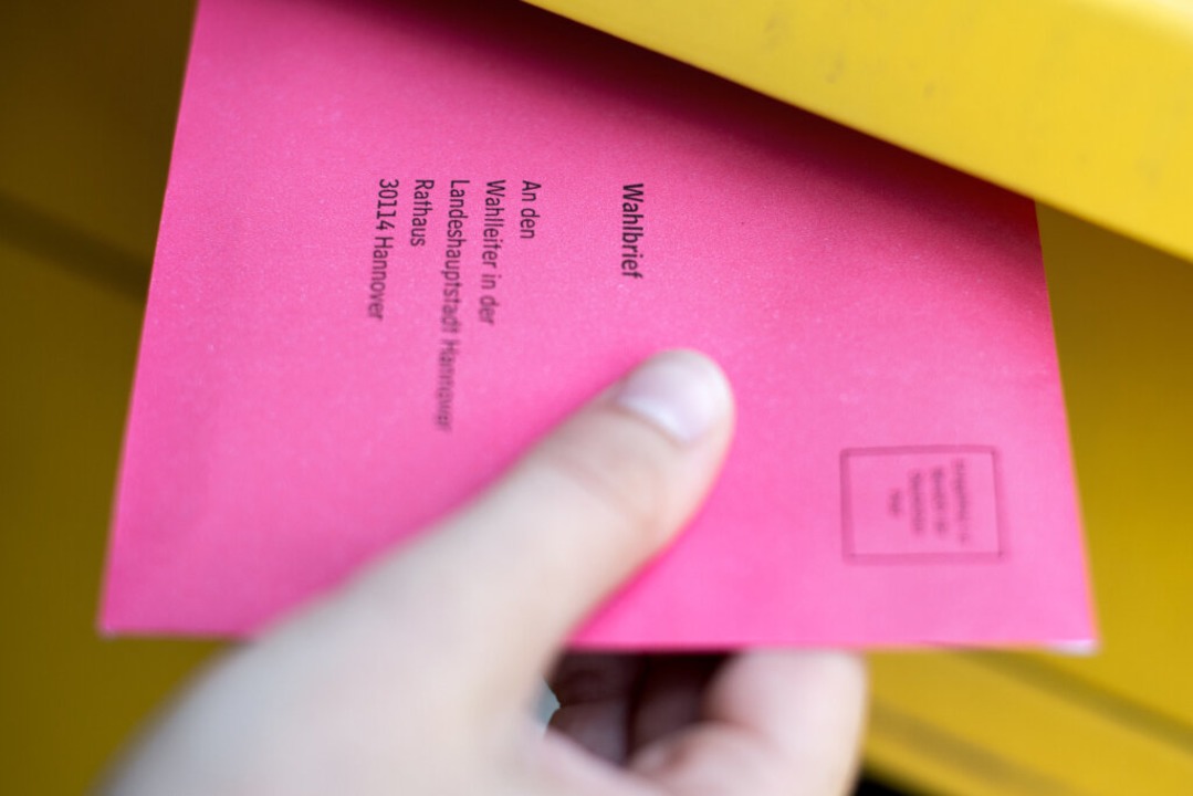 Eine Frau steckt einen Wahlbrief für die Bundestagswahl in einen Postkasten.  | Foto: Hauke-Christian Dittrich (dpa)