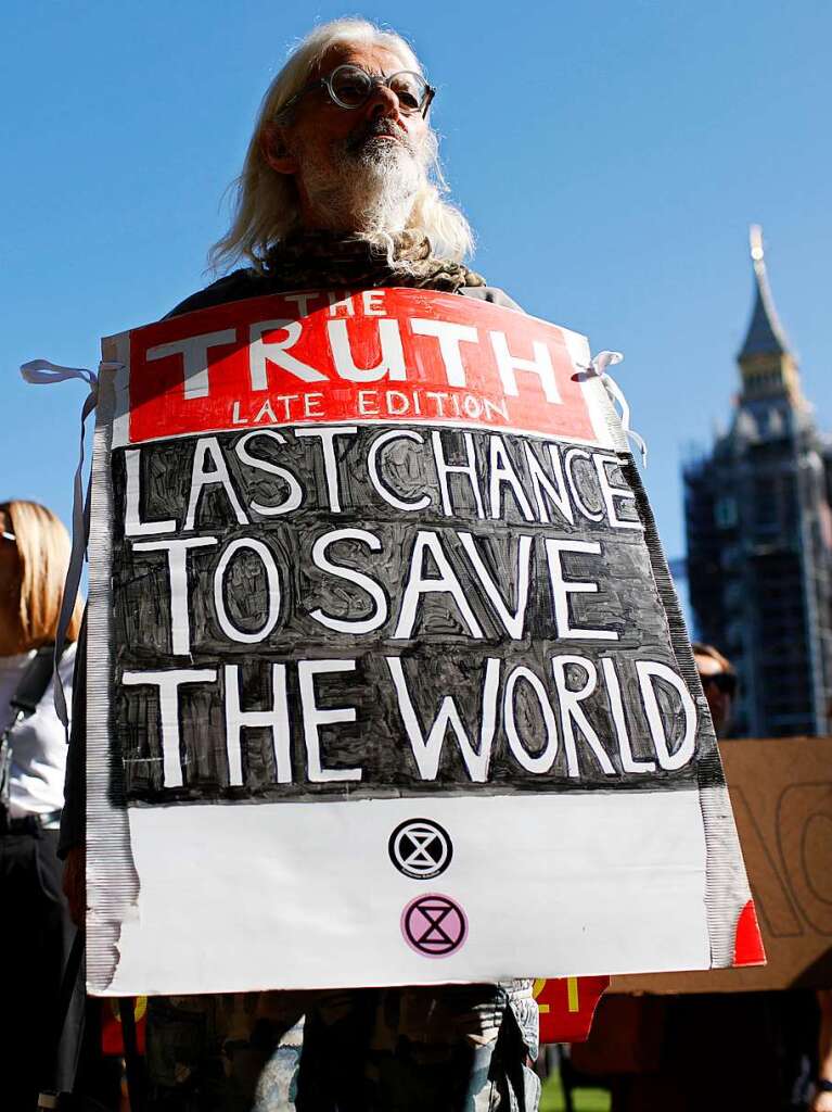 In London steht ein Mann mit einem Plakat auf einer Klimademo von Fridays for Future. Grobritannien richtet dieses Jahr die Klimakonferenz der Vereinten Nationen aus.