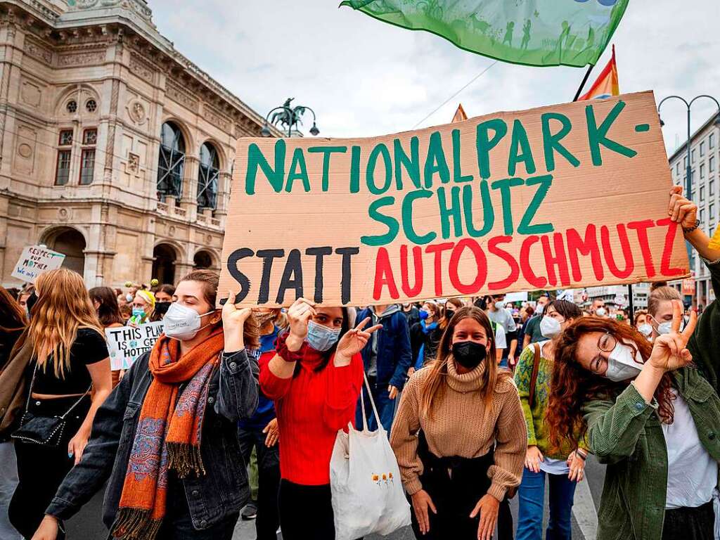 Junge Demonstranten halten in Wien ein Protestschild hoch.