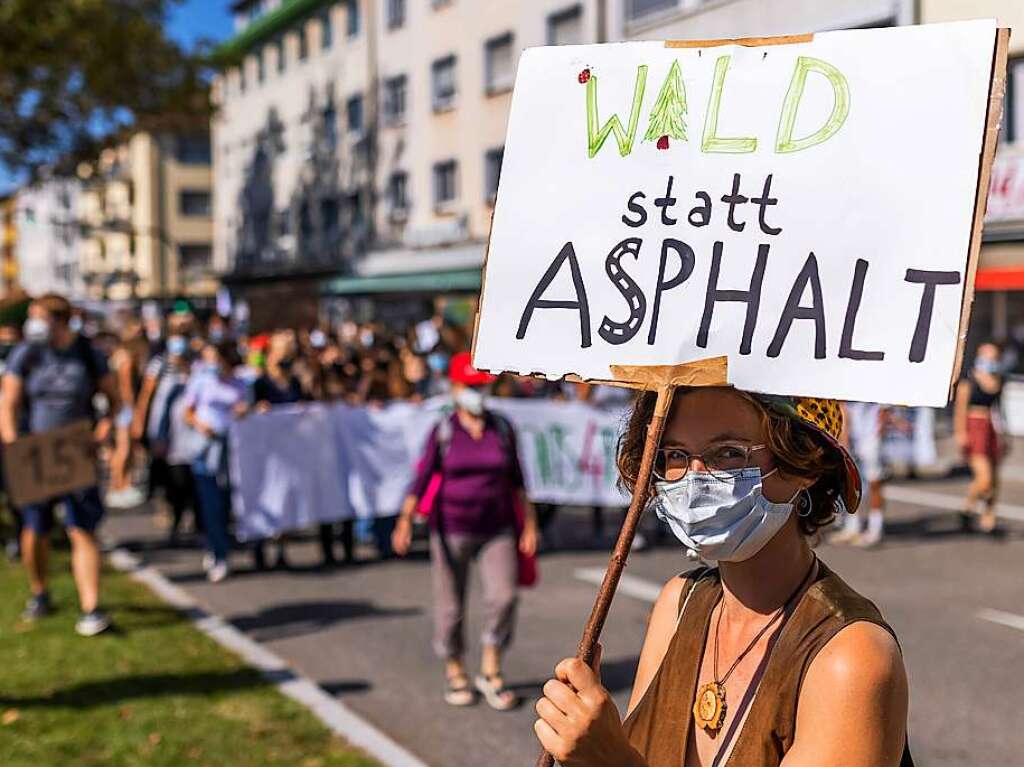 In Freiburg hlt eine Demonstrantin ein Plakat mit der Aufschrift „Wald statt Asphalt“ hoch.