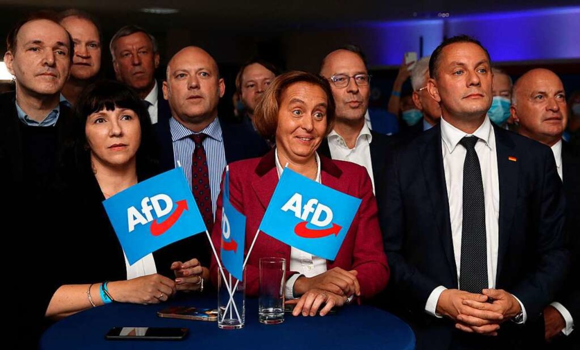 Parteisprecher Tino Chrupalla (2.v.r.)...r.) betrachten die  ersten Ergebnisse.  | Foto: RONNY HARTMANN (AFP)