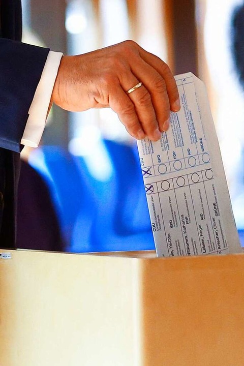 Armin Laschet wirft seinen Stimmzettel...er gewählt hat, ist deutlich sichtbar.  | Foto: THILO SCHMUELGEN (AFP)