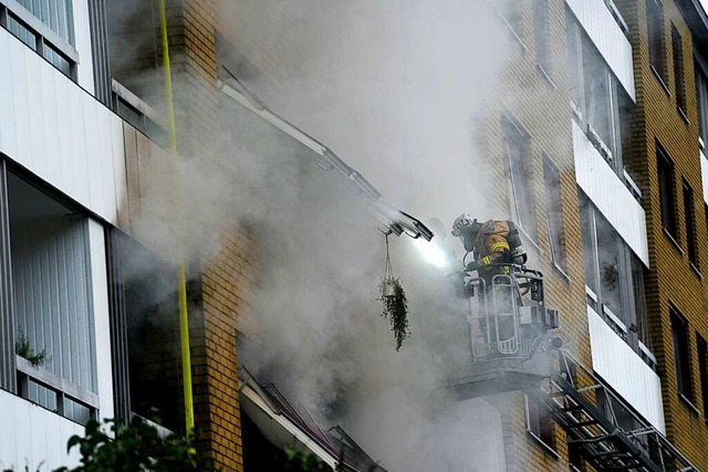 Ein Feuerwehrmann ist nach einer Explosion in einem Wohnhaus im Einsatz.  | Foto: Bjorn Larsson Rosvall (dpa)