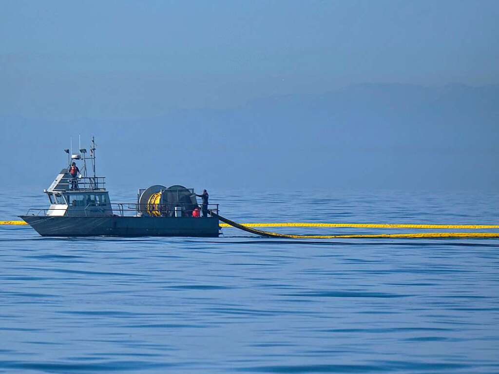 Ein Boot der Marine Spill Response Corporation (MSRC), einer Organisation zur Beseitigung von lverschmutzungen (OSRO), setzt  „Booms“ (schwimmende Barrieren) ein, um ein weiteres Ausbreiten des lteppichs vor Huntington Beach zu verhindern.