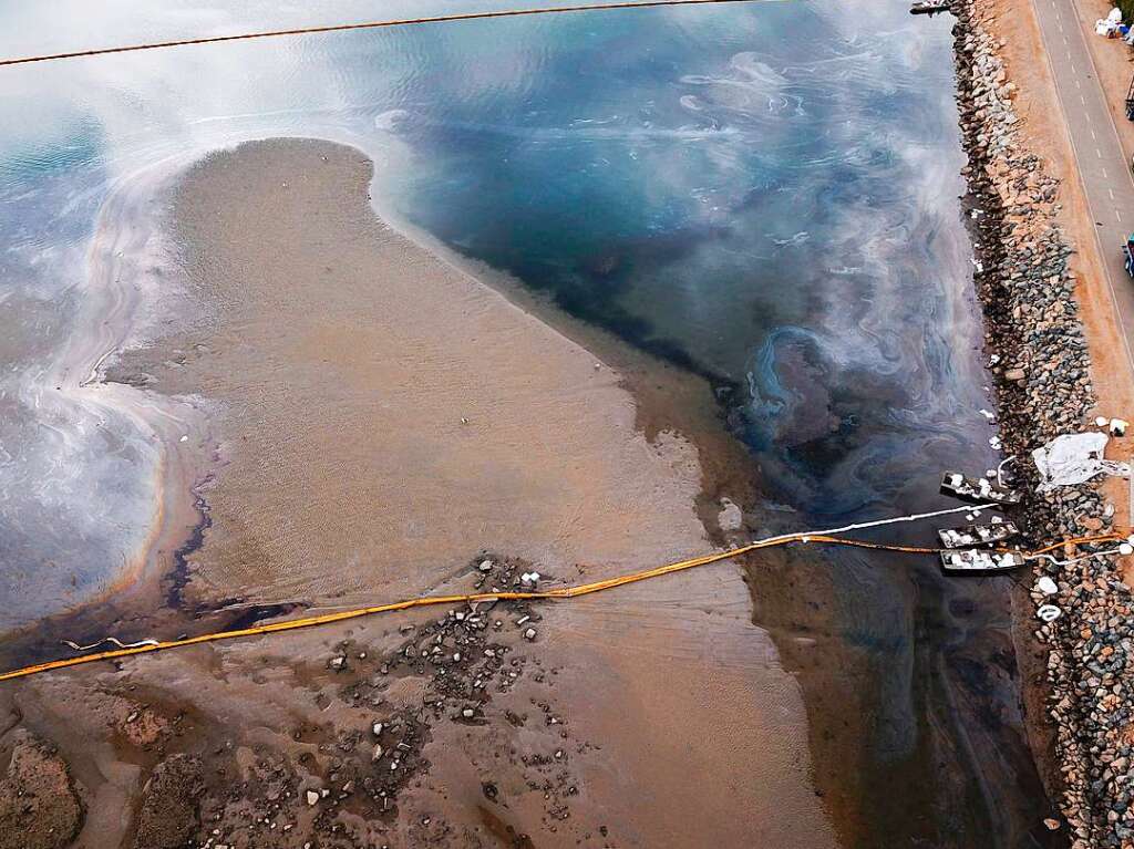 Schwimmende Barrieren sollen ein weiteres Ausbreiten des lteppichs vor Huntington Beach verhindern.