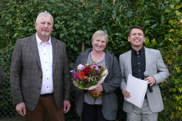 Wahlleiter Volker Fischer (rechts) gra...einer Frau Annette einen Blumenstrau.  | Foto: Victoria Langelott