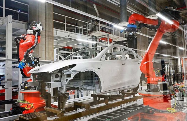 Roboter bei der Fertigung vom Tesla Mo...roduktionshalle der Tesla Gigafactory.  | Foto: Patrick Pleul (dpa)