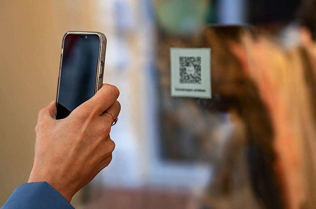 Mit Smartphone, QR-Code und der Luca-A...oll die Kontaktverfolgung erleichtern.  | Foto: AXEL HEIMKEN (AFP)