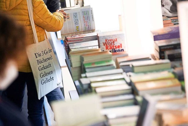 Eine Frau blttert durch ein Buch, am ...ertag der  Frankfurter Buchmesse 2021.  | Foto: Sebastian Gollnow (dpa)