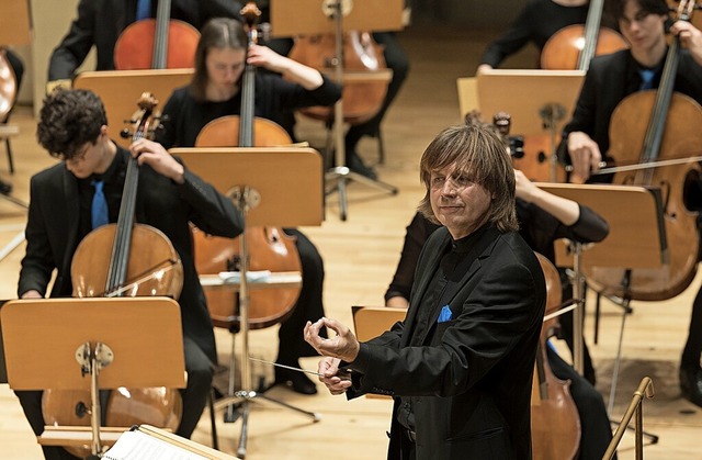 Dirigent Wolfgang Hentrich bei der Arbeit mit dem Orchester  | Foto: Kai Bienert