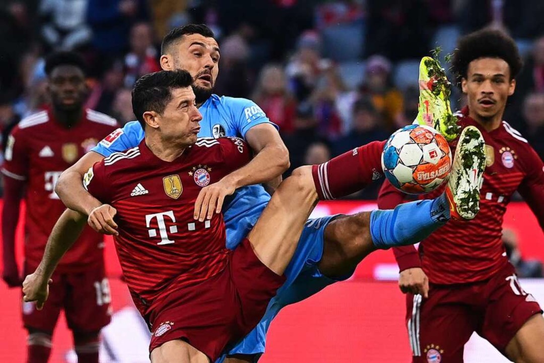 Mnchens Robert Lewandowski (vorn) km...nuel Gulde, rechts Mnchens Leroy Sane  | Foto: Sven Hoppe (dpa)