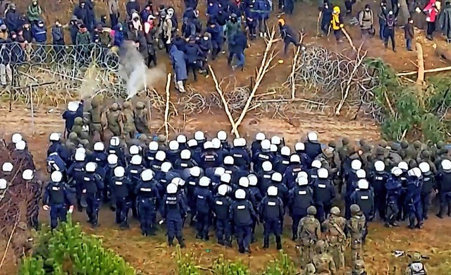 An der polnisch-litauischen Grenze ste...anten und Sicherheitskrfte gegenber.  | Foto: HANDOUT (AFP)