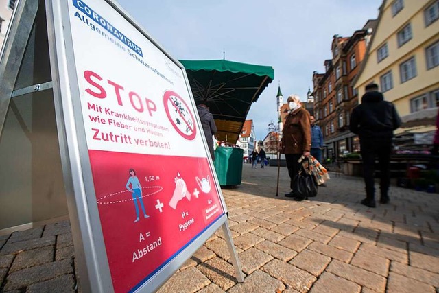 Vor dem Wochenmarkt weist ein Schild auf die Corona- Manahmen hin.  | Foto: Stefan Puchner (dpa)