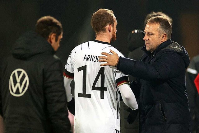 Bundestrainer Hansi Flick (rechts) bed... nach dem Spiel bei Maximilian Arnold.  | Foto: Christian Charisius (dpa)