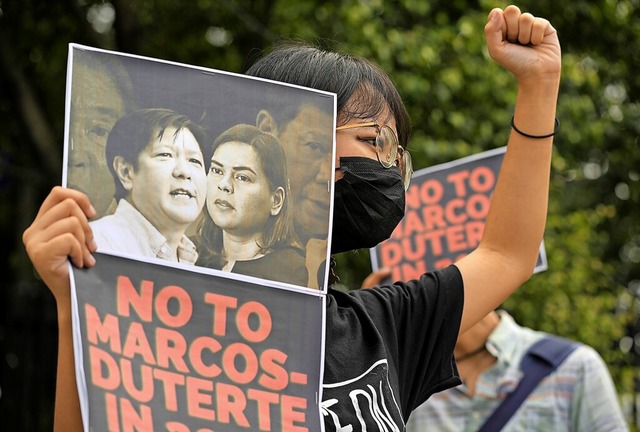Ein Demonstrant in Quezon protestiert ...nand Marcos Jr. (l.) und  Sara Duterte  | Foto: Aaron Favila (dpa)