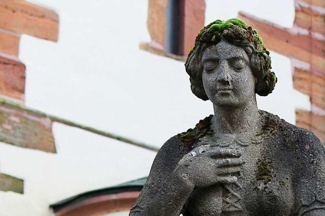 An der Kirche in Gundelfingen neigt eine trauernde Frau ihr Haupt