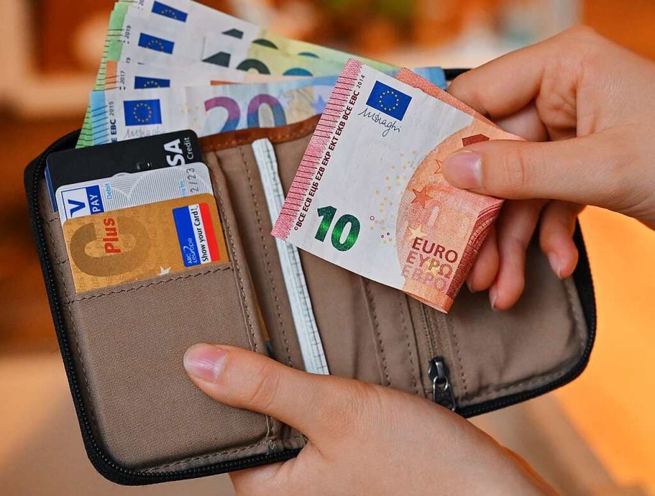 Viele Geldscheine stecken in einem Geldbeutel, als auch Bankkarten.  | Foto: Patrick Pleul