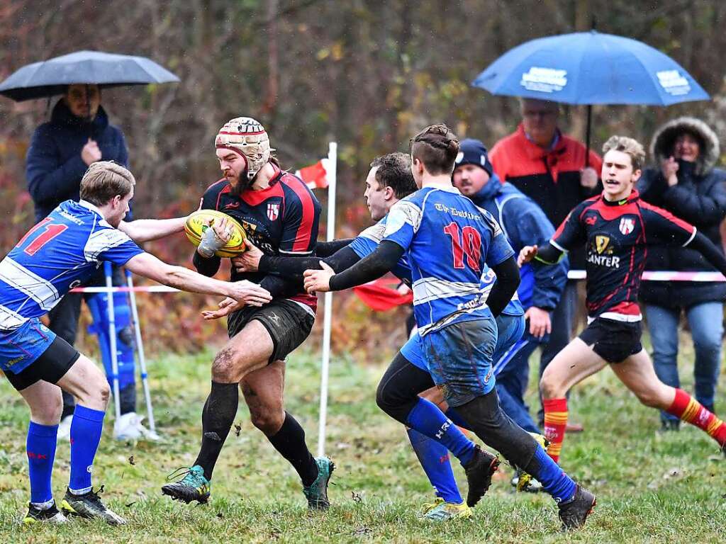 Kampf, Matsch und mehr: Impressionen vom Drittliga-Rugbyspiel zwischen Freiburg (in schwarz-rot) und Heidelberg (blau-wei).