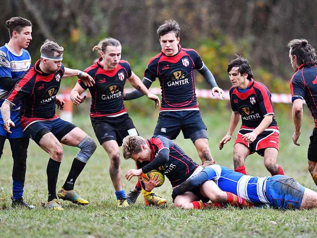 Kampf, Matsch und mehr: Impressionen vom Drittliga-Rugbyspiel zwischen Freiburg (in schwarz-rot) und Heidelberg (blau-wei).