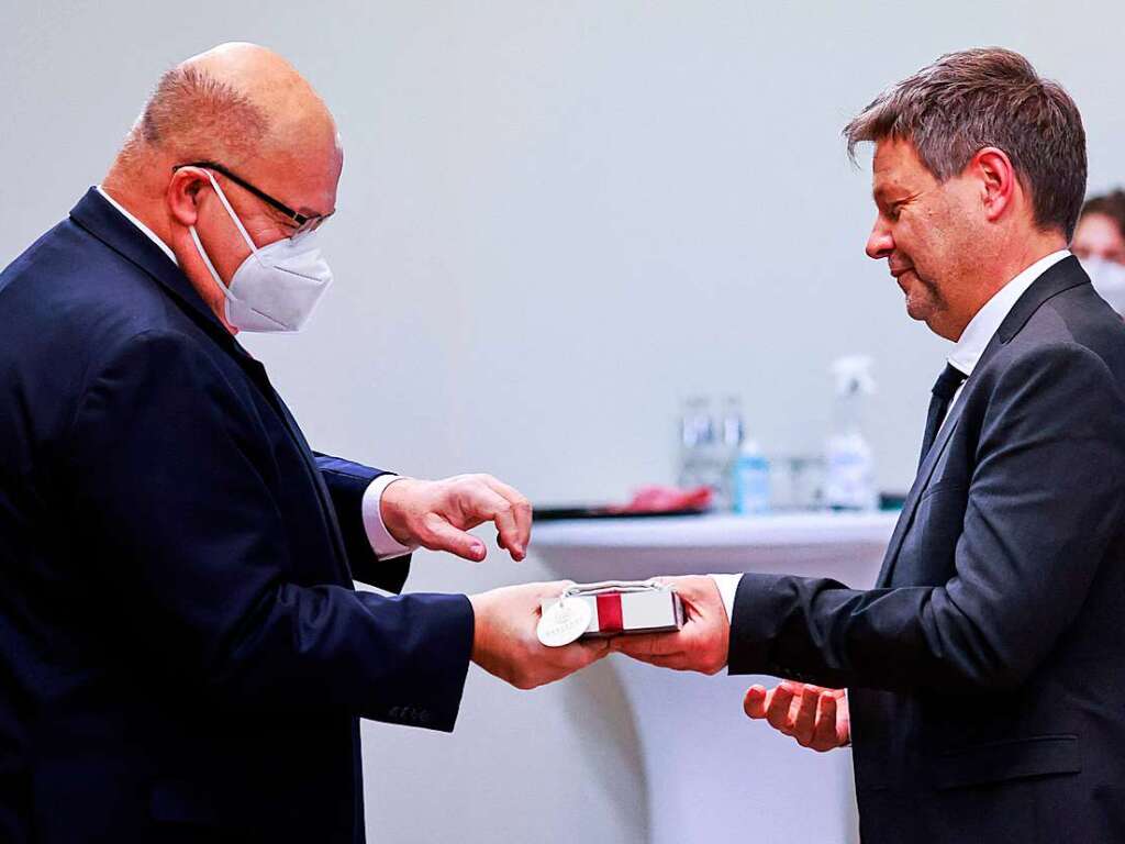 Peter Altmaier (CDU) bergibt ein Geschenk an Robert Habeck  (Bndnis 90/Die Grnen).