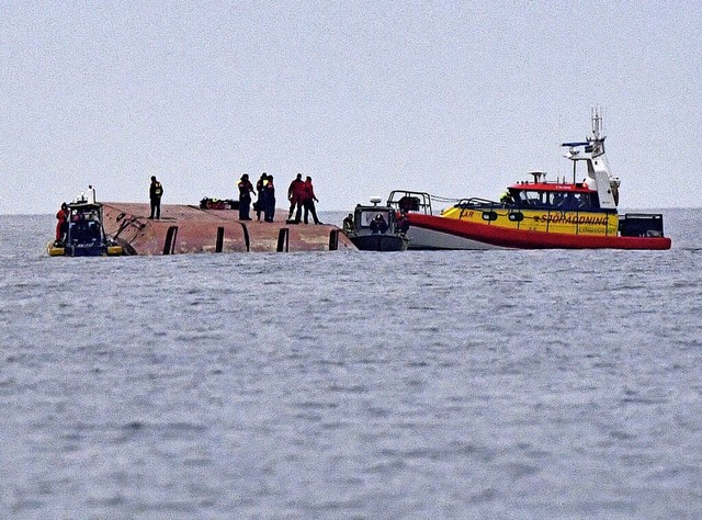 Seenotretter und Taucher auf dem gekenterten dnischen Schiff Karin Hoj.  | Foto: JOHAN NILSSON (AFP)