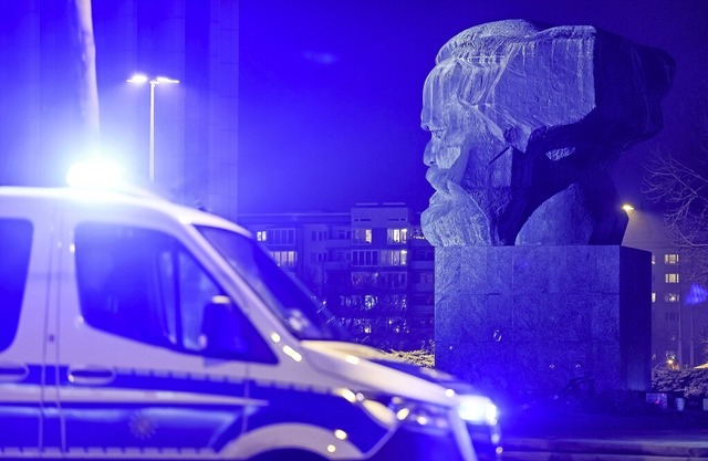 Ein Polizeiwagen steht am Rande einer ...-Denkmal in der Chemnitzer Innenstadt.  | Foto: Jan Woitas (dpa)