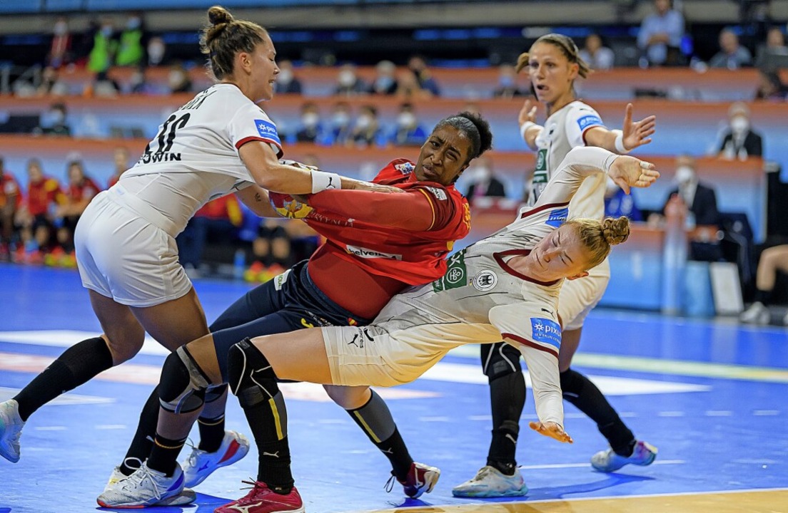 Emily Bölk, die Spanierin Kaba Gassama... links) kämpfen  am Kreis um den Ball.  | Foto: Marco Wolf (dpa)