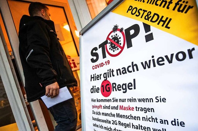 Ein Plakat weist Kunden vor einem Copyshop auf die dort geltende 1G-Regel hin.  | Foto: Christoph Schmidt (dpa)