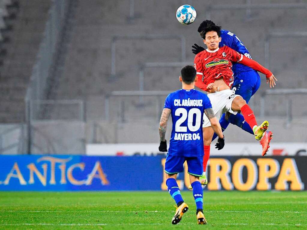 Freiburgs Strmer Jeong im Luftduell mit Leverkusens Kossounou.