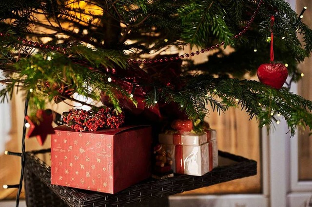 Zwei Geschenke liegen schn verpackt unter einem Weihnachtsbaum.  | Foto: Annette Riedl (dpa)